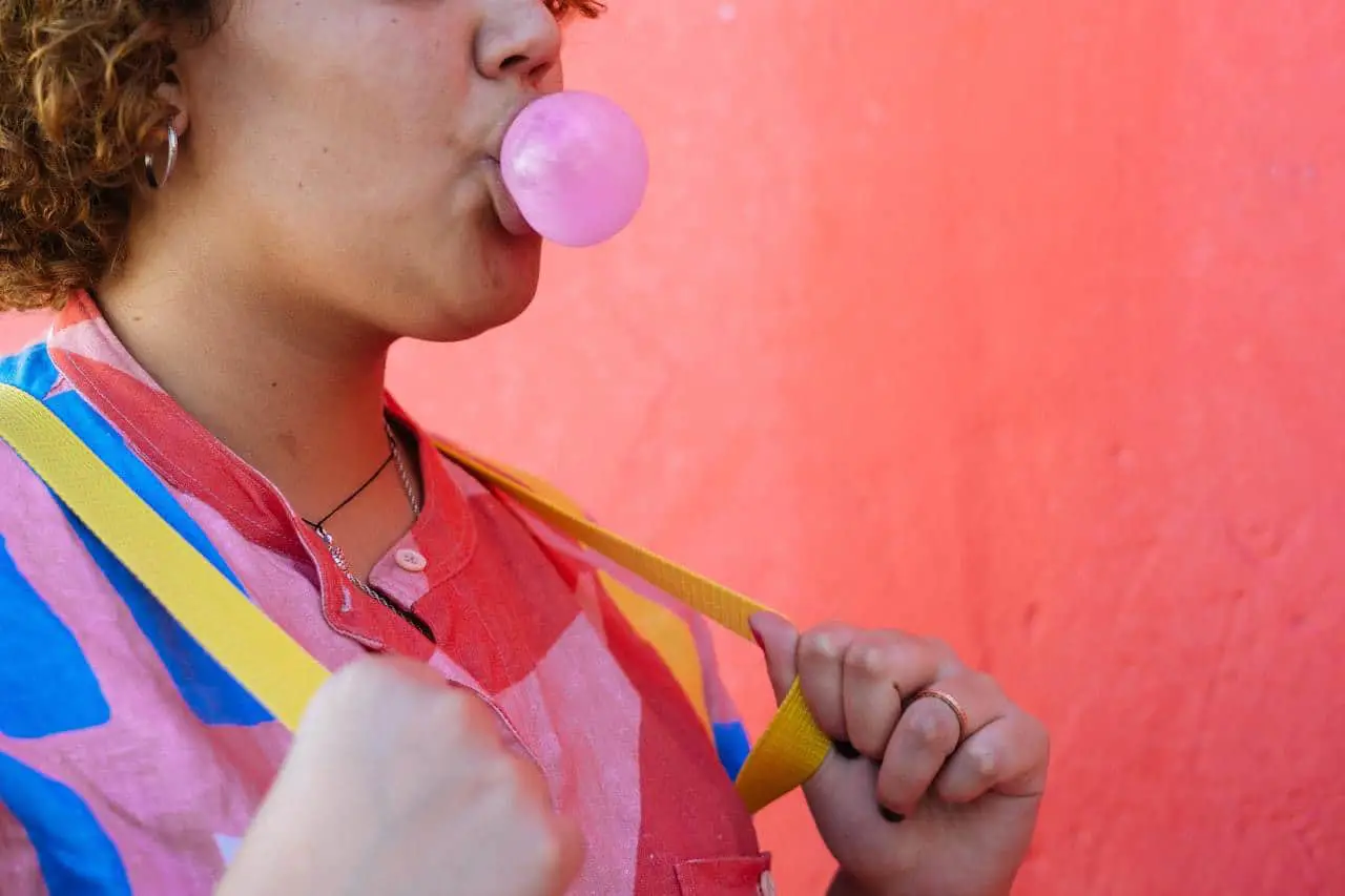 anonymous colorful lady blowing gum bubble in street 3843251