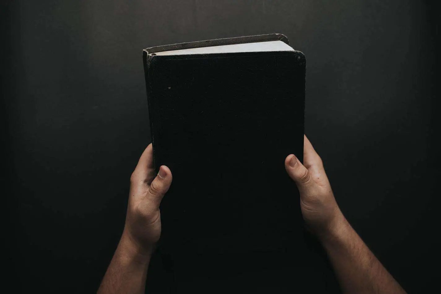 person holding black cover bible 2258240 1